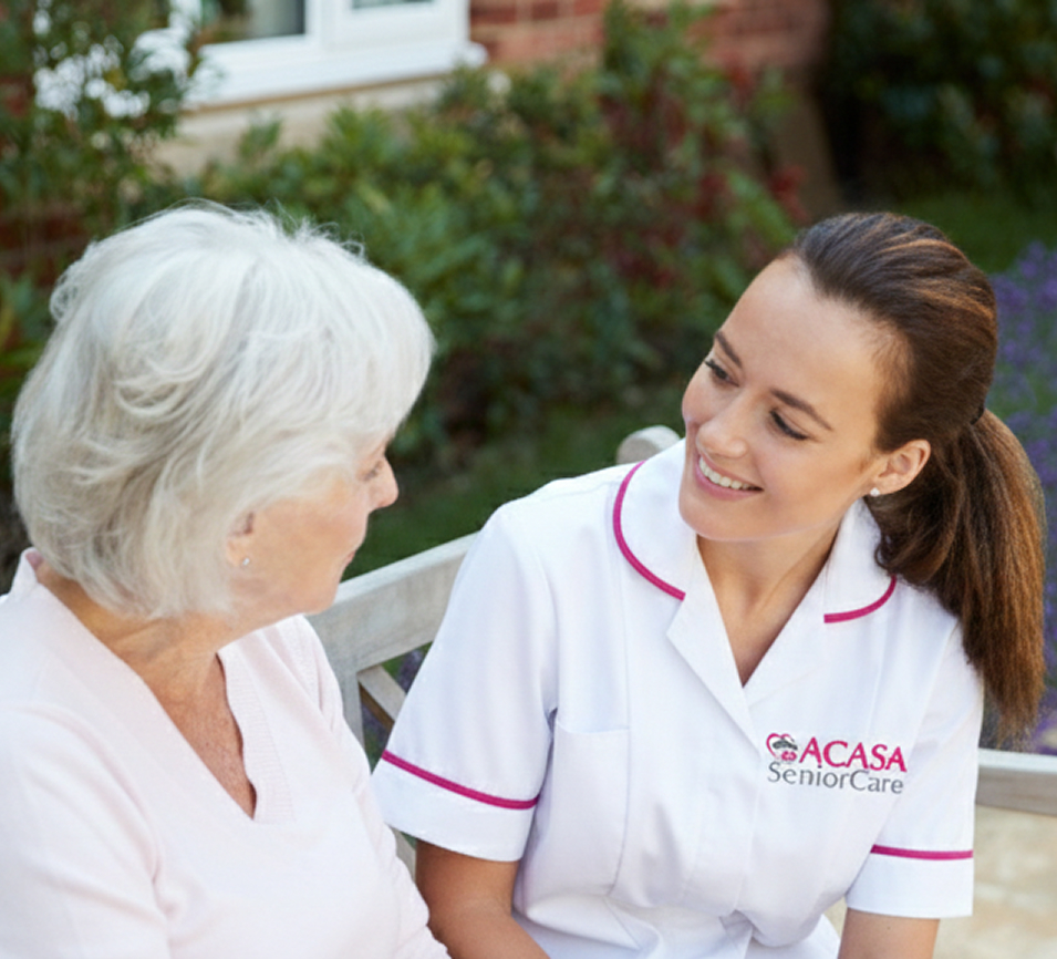 Caregiver providing support to an elderly woman outside.