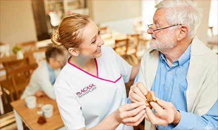 A caregiver assisting an elderly man with a warm smile, highlighting compassionate home care services.